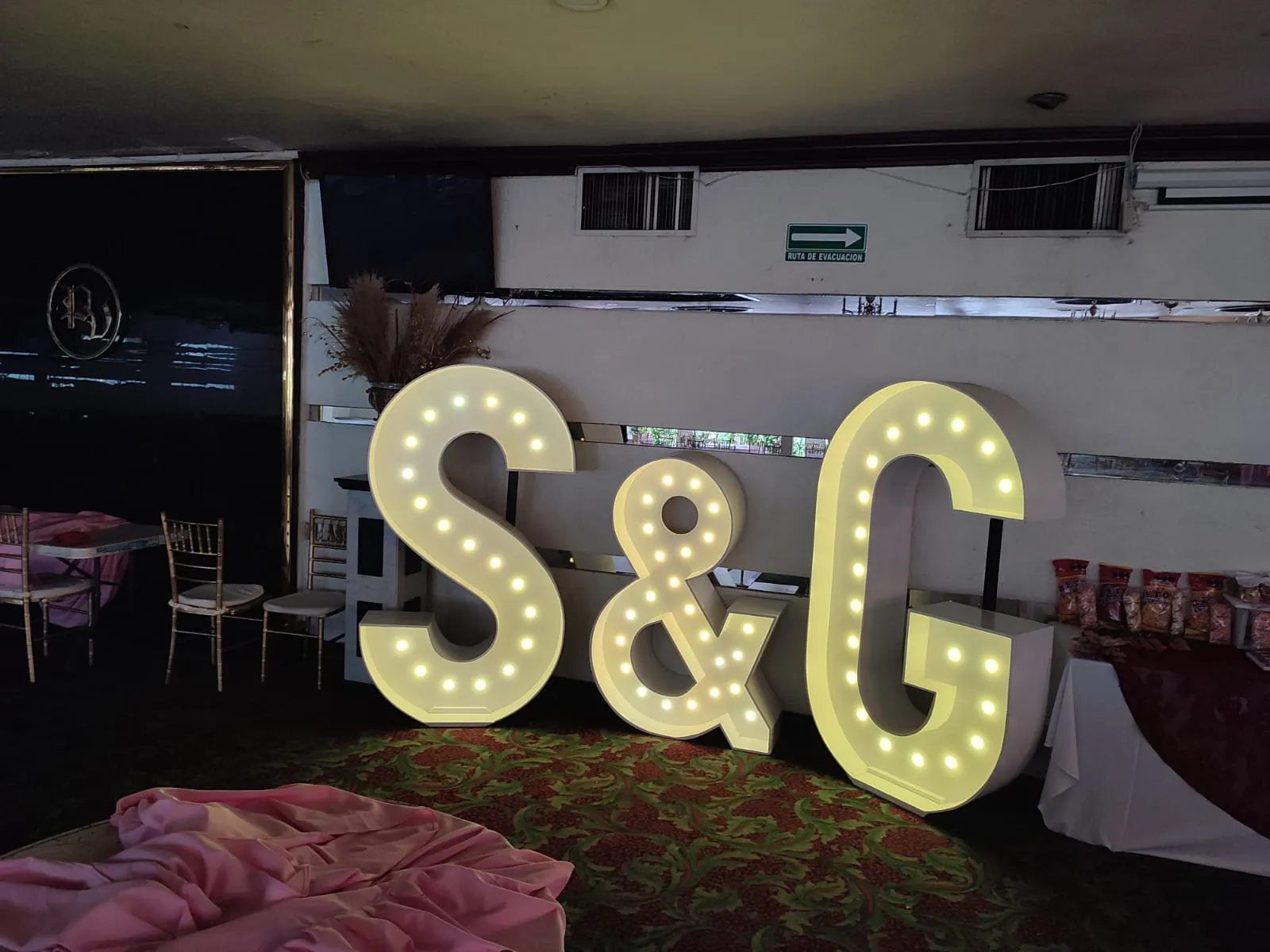 Iniciales gigantes iluminadas S y G en una boda