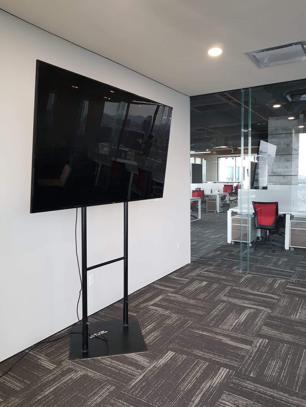 Pantalla montada en soporte metálico con base de piso
